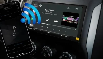 A cellphone with bluetooth bars coming out of it going towards a car audio radio screen